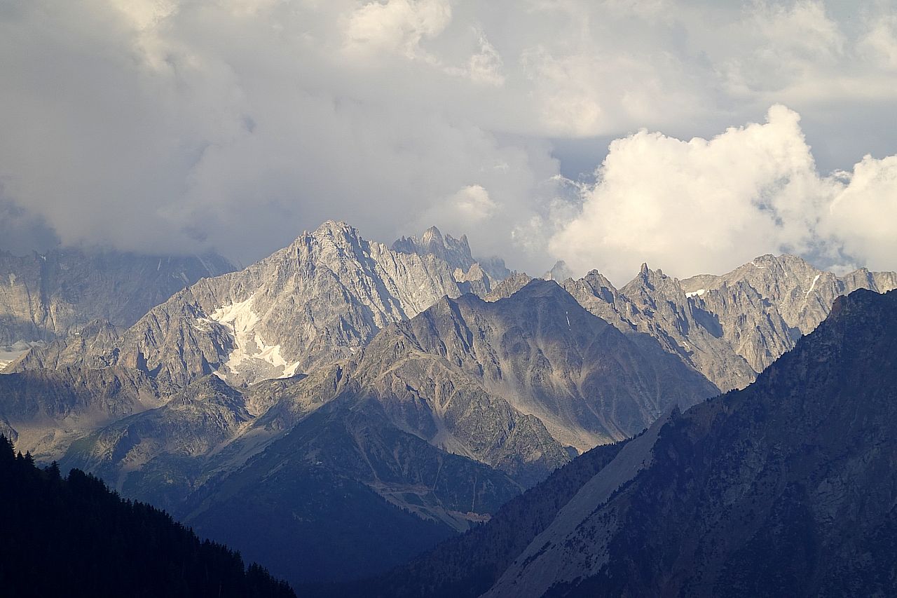 Blick auf ein paar Berggipfel, einige mit Wolken verhangen